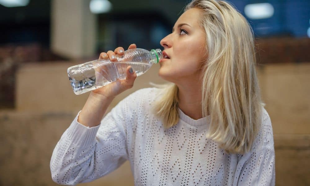 a girl drinking from plastic bottled water